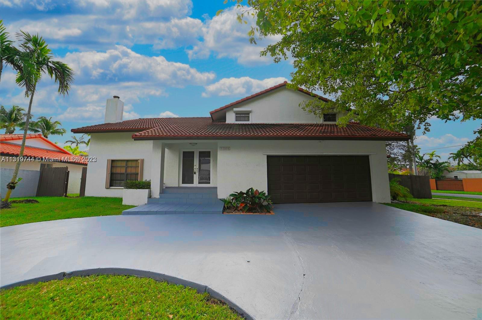 11990 Southwest 92nd Street Miami, FL 33186 - Photo 2 of 33 a front view of a house with a garden and yard