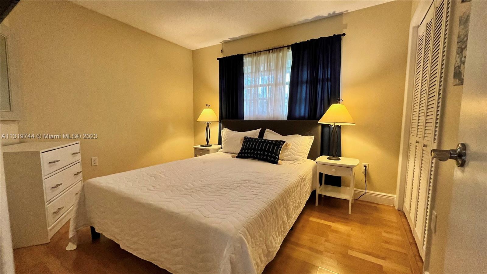 11990 Southwest 92nd Street Miami, FL 33186 - Photo 24 of 33 a bedroom with a bed and a lamp