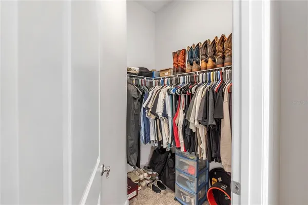 a view of walk in closet with clothes