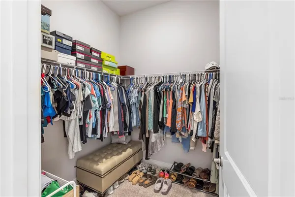 a view of walk in closet with clothes and shoes