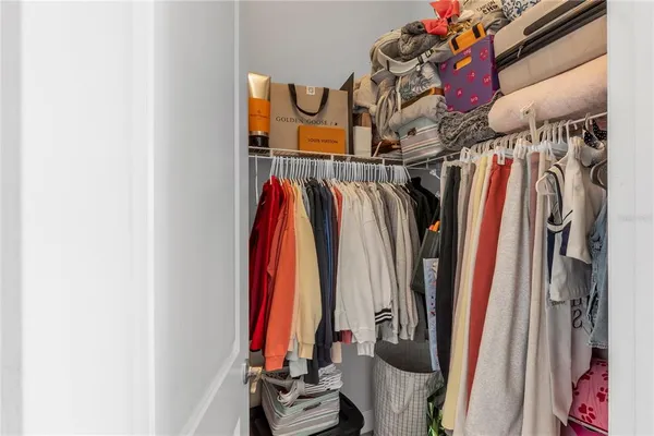 a view of walk in closet with clothes