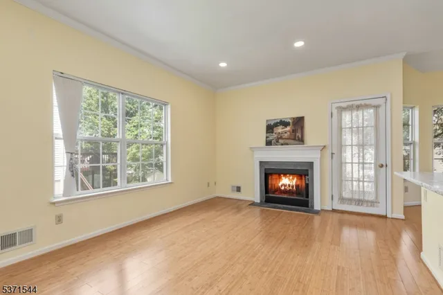 a view of an empty room with a window and fireplace