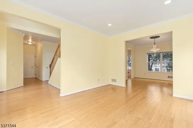 a view of a big room with wooden floor and windows