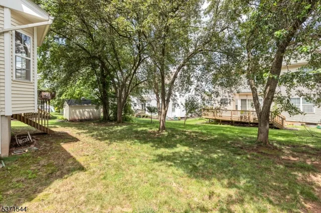 a view of a yard with a house and a large tree