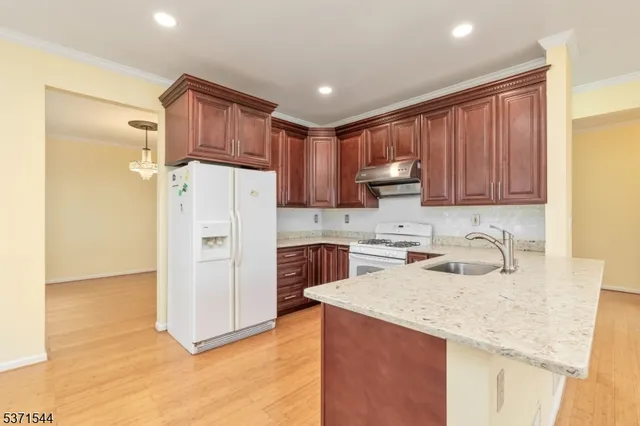 a kitchen with a refrigerator sink and cabinets
