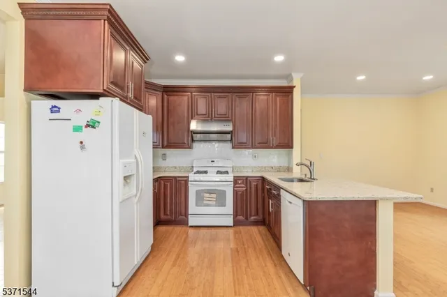 a kitchen with a sink a refrigerator a microwave and cabinets
