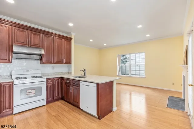 a kitchen with stainless steel appliances granite countertop a stove a sink and a microwave
