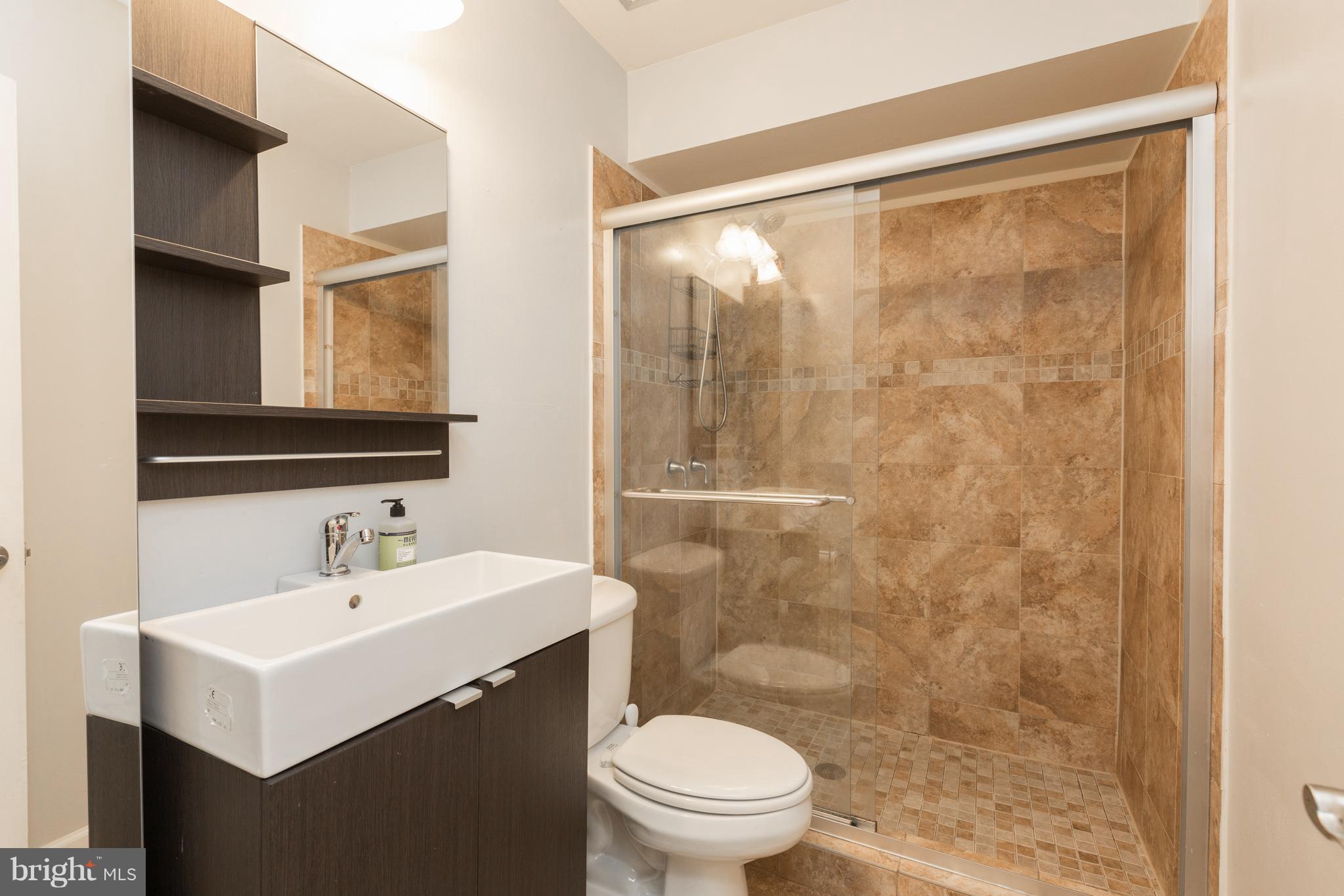 8355 Dunham Court, Unit 607 Springfield, VA 22152 - Photo 11 of 15 a bathroom with a sink mirror toilet and shower