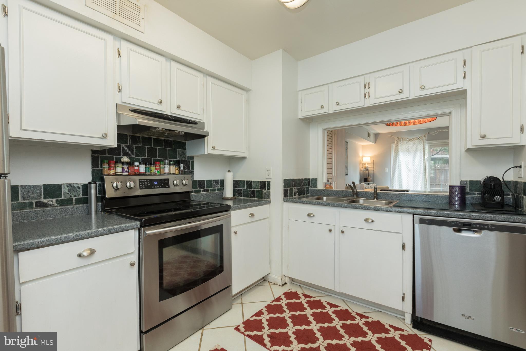 8355 Dunham Court, Unit 607 Springfield, VA 22152 - Photo 5 of 15 a kitchen with granite countertop white cabinets and stainless steel appliances