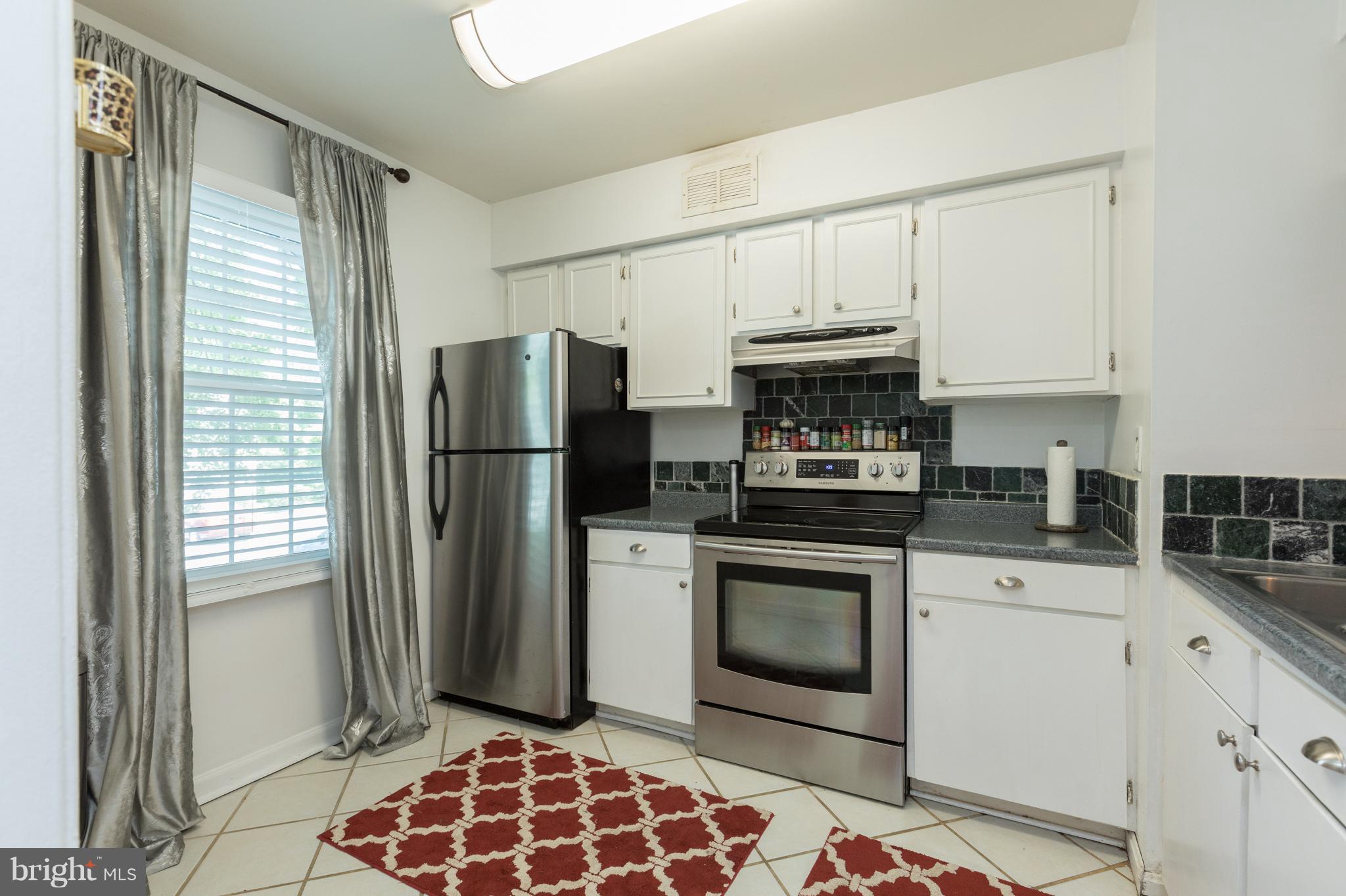 8355 Dunham Court, Unit 607 Springfield, VA 22152 - Photo 6 of 15 a kitchen with stainless steel appliances granite countertop a refrigerator sink and stove