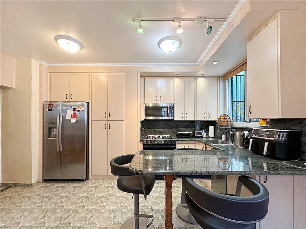 18 Corbin Place Brooklyn, NY 11235 - Photo 6 of 22 a kitchen with stainless steel appliances granite countertop a sink a refrigerator and a stove