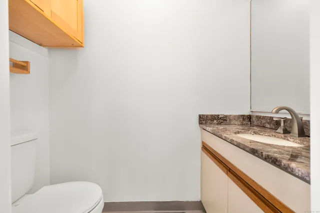 a bathroom with a granite countertop toilet and sink
