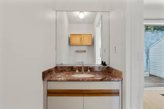 a bathroom with a granite countertop sink and a mirror