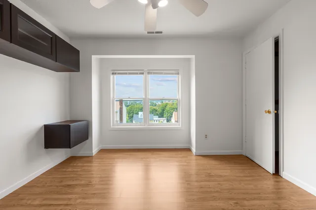 an empty room with wooden floor and windows