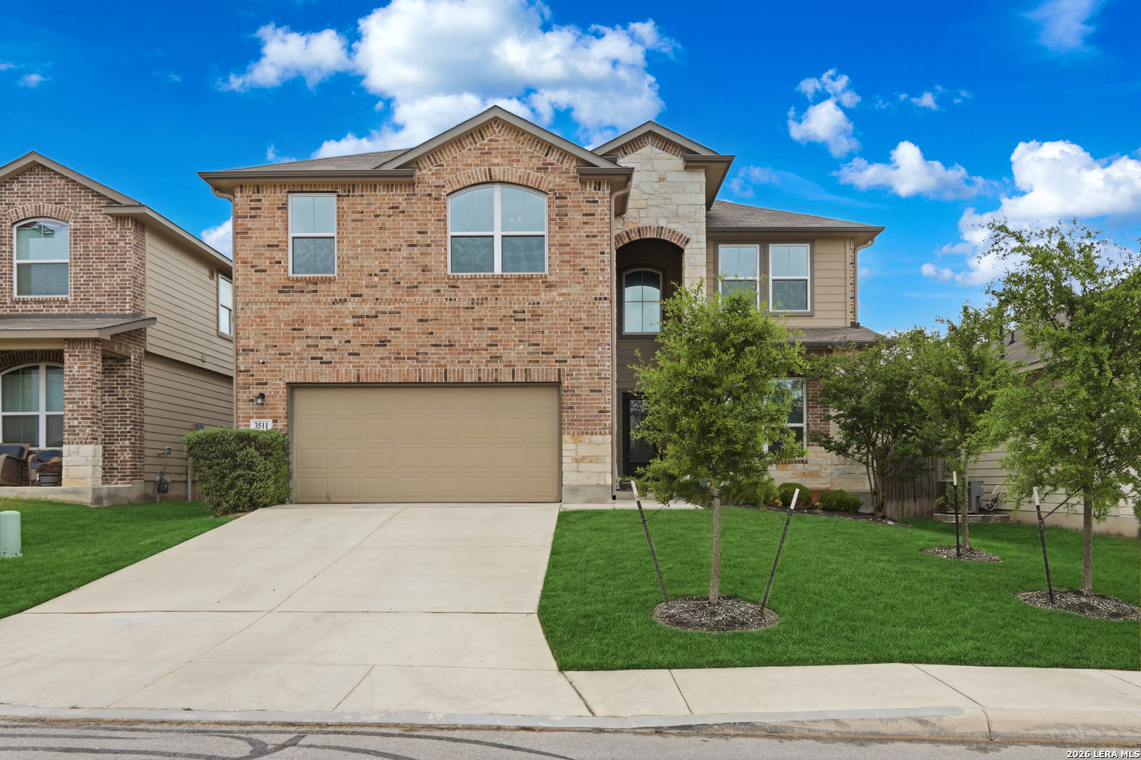 a front view of a house with a yard and a garage