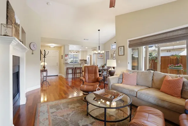 a dining room with wooden floor a chandelier a wooden table and chairs
