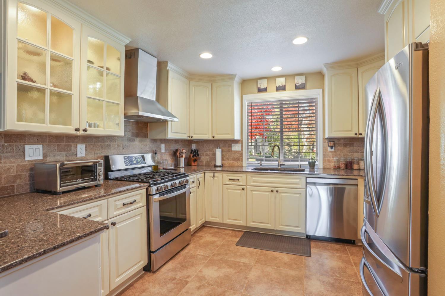 2832 Remington Way Tracy, CA 95377 - Photo 19 of 67 a kitchen with stainless steel appliances granite countertop a stove a sink and a refrigerator