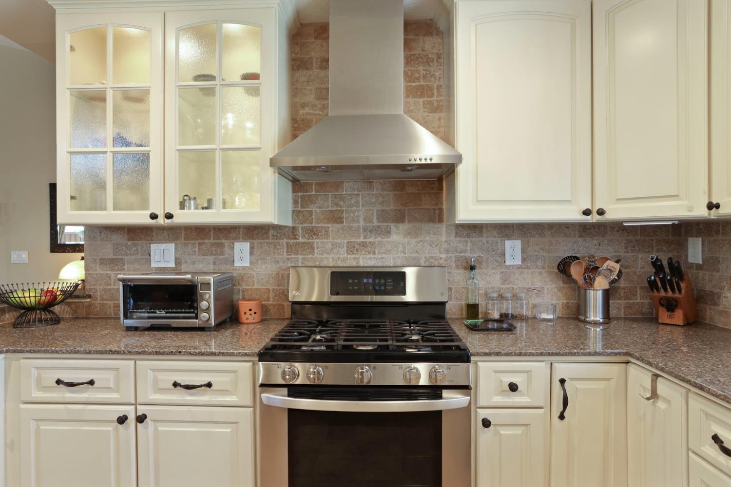 2832 Remington Way Tracy, CA 95377 - Photo 21 of 67 a kitchen with granite countertop white cabinets and appliances