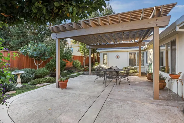 a view of a patio with table and chairs potted plants