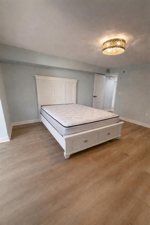 676 El Centro Longboat Key, FL 34228 - Photo 4 of 6 a bedroom with a bed and a chandelier
