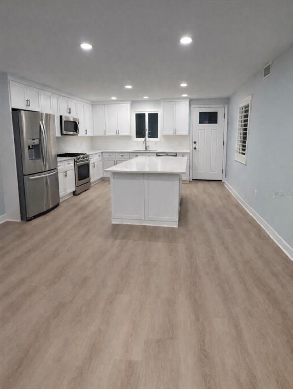 676 El Centro Longboat Key, FL 34228 - Photo 5 of 6 a large kitchen with stainless steel appliances granite countertop a stove a sink a refrigerator and white cabinets