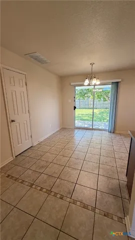 a view of a livingroom with a chandelier fan and windows