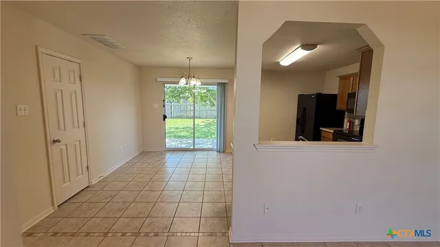an empty room with windows and fireplace