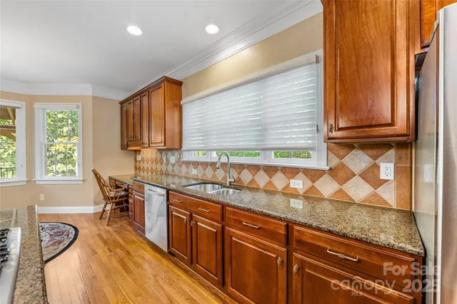 a kitchen with granite countertop wooden cabinets and a window