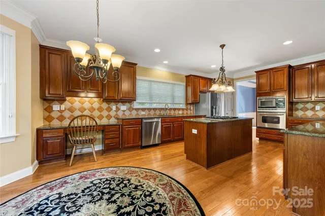 a kitchen with stainless steel appliances kitchen island granite countertop a refrigerator a stove a sink dishwasher with a dining table and chairs with wooden floor