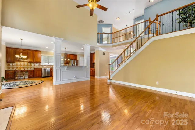 a view of a livingroom with wooden floor and a kitchen space