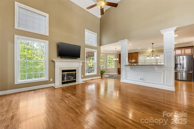a view of a livingroom with a fireplace wooden floor and a window