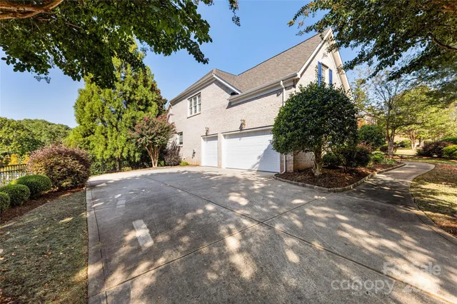 a view of a white house with a large tree