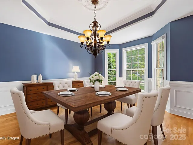 a view of a dining room with furniture a chandelier and wooden floor