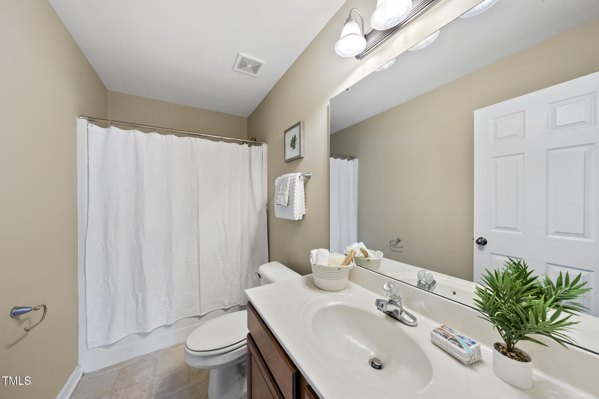 9910 Clyborn Court Raleigh, NC 27617 - Photo 17 of 19 a bathroom with a sink a toilet and shower curtain