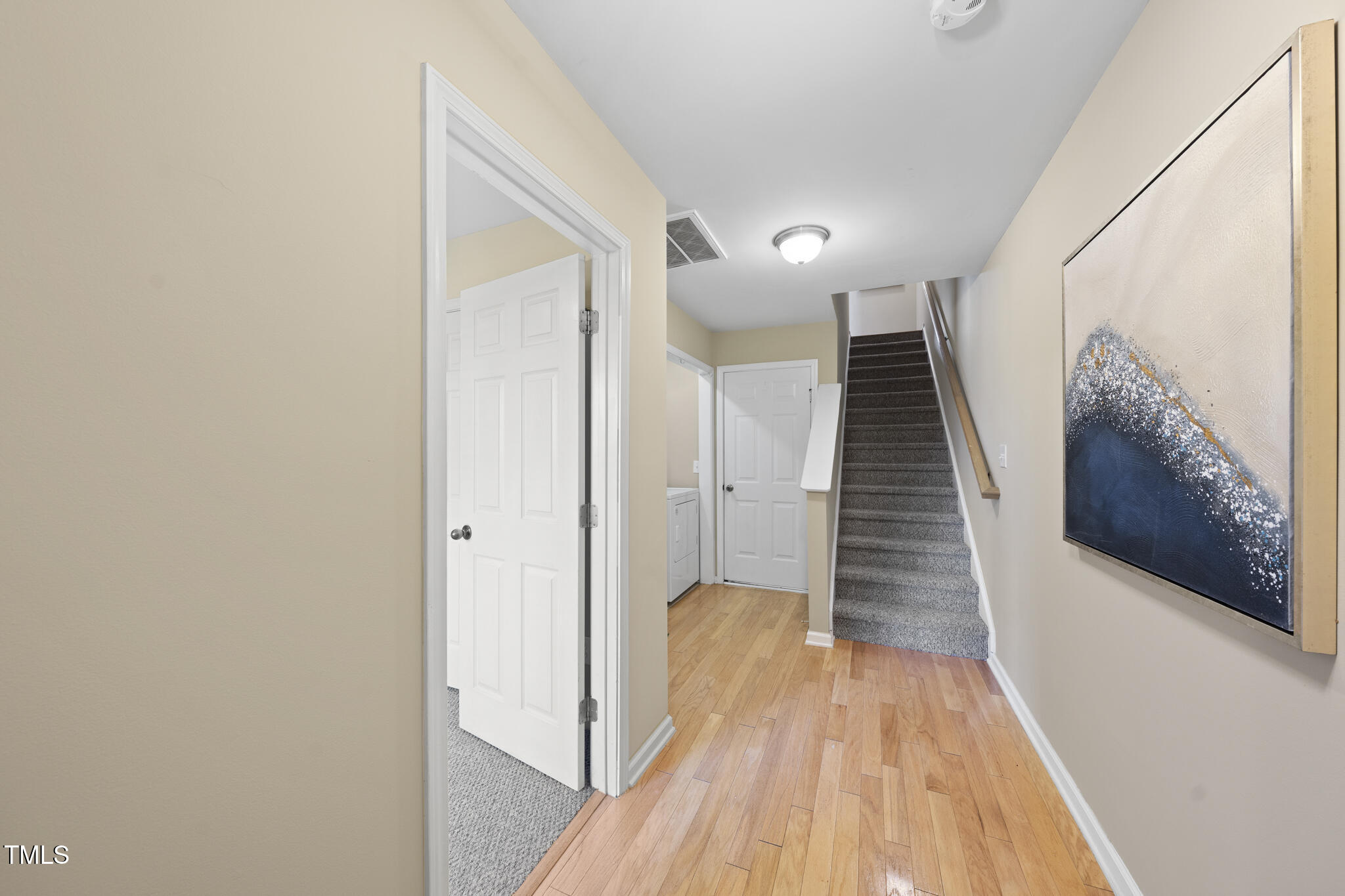 9910 Clyborn Court Raleigh, NC 27617 - Photo 3 of 19 a view of a hallway with wooden floor and staircase