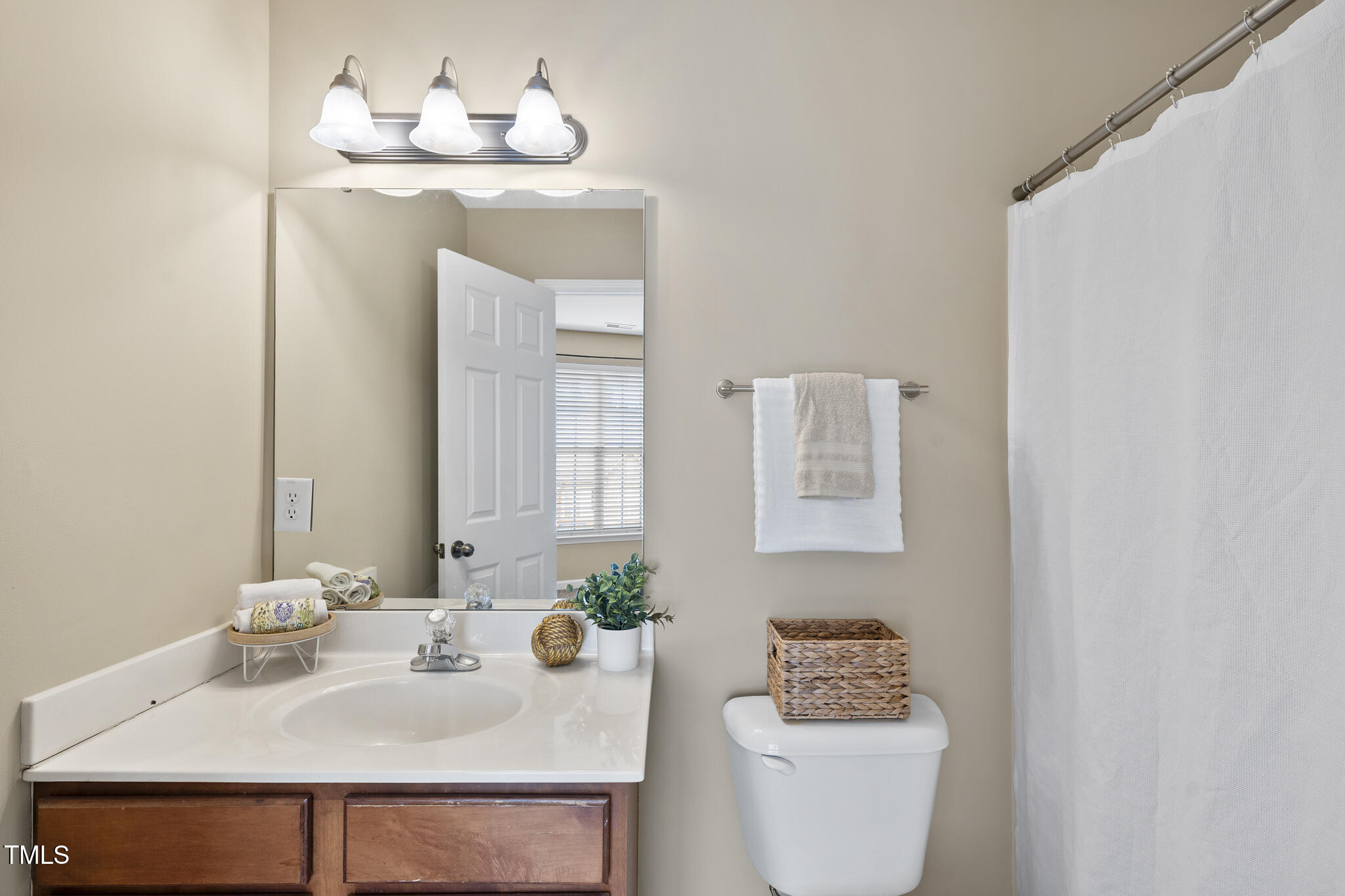 9910 Clyborn Court Raleigh, NC 27617 - Photo 5 of 19 a bathroom with a sink and a mirror