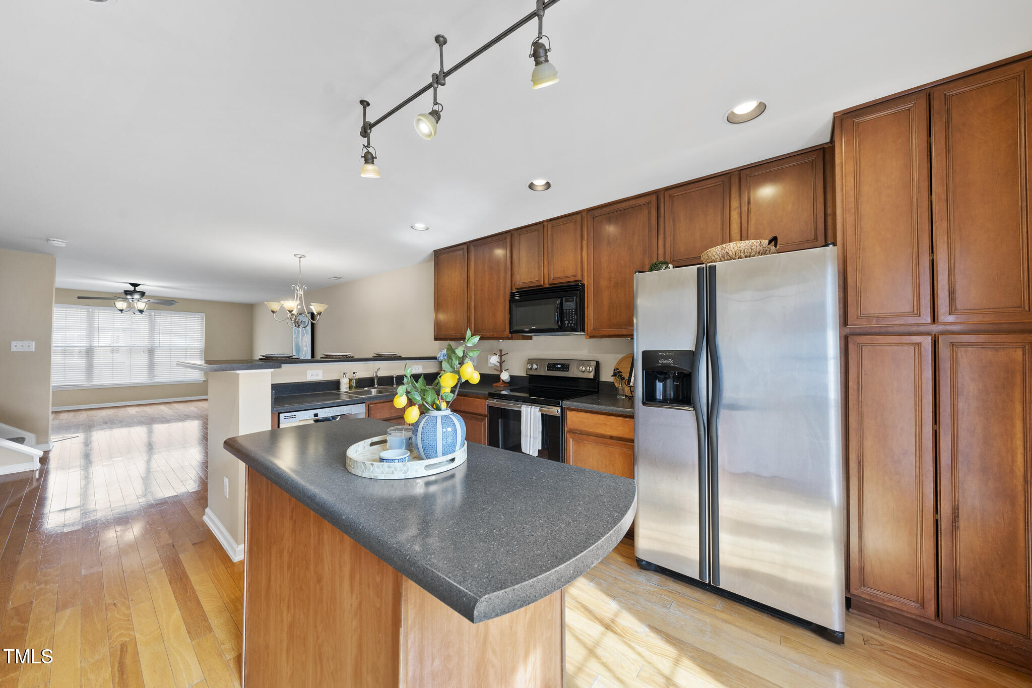 9910 Clyborn Court Raleigh, NC 27617 - Photo 7 of 19 a kitchen with stainless steel appliances granite countertop a refrigerator a stove top oven a sink dishwasher and white cabinets with wooden floor