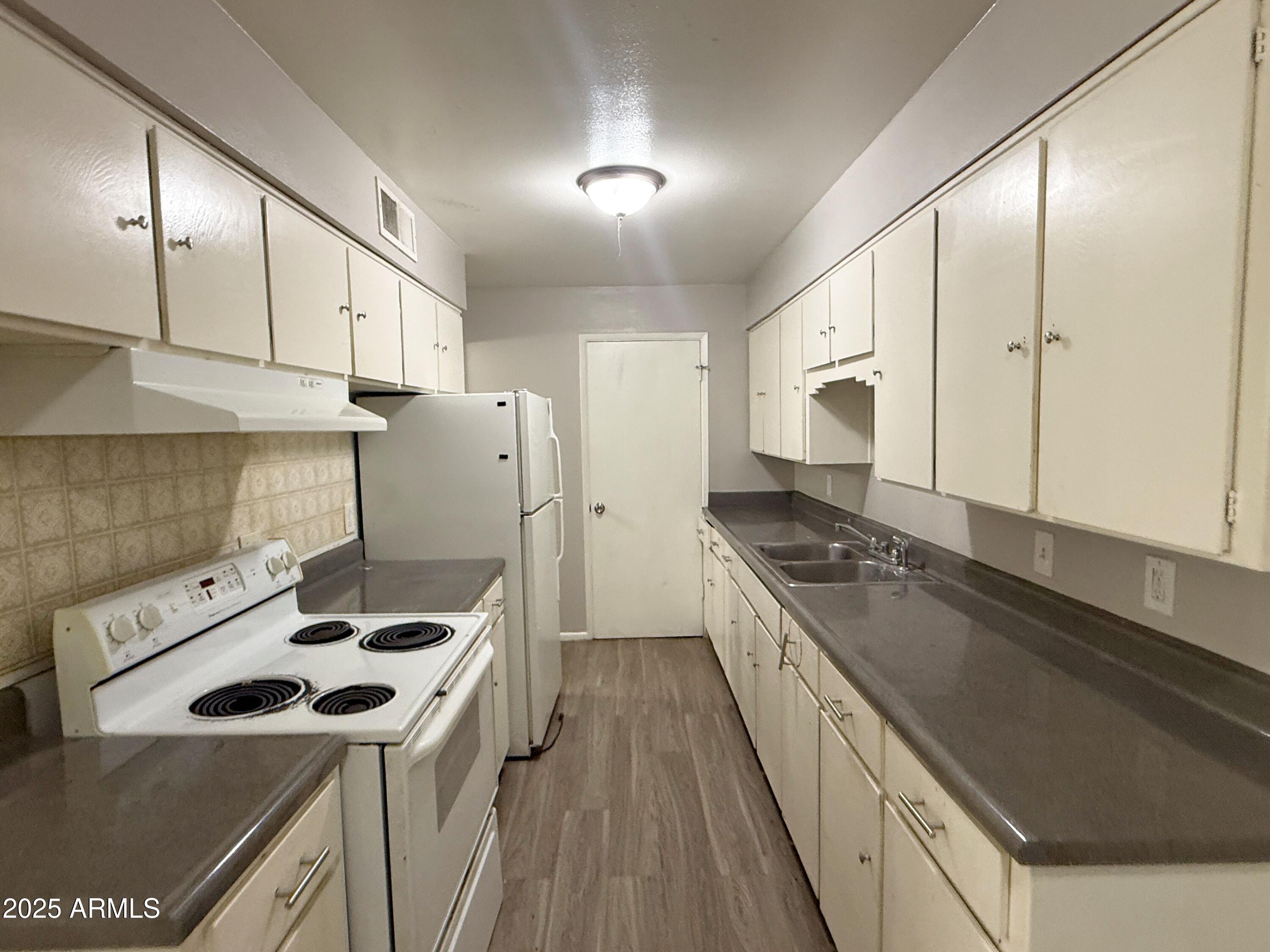 4719 North 15th Avenue, Unit 3 Phoenix, AZ 85015 - Photo 5 of 12 a kitchen with a stove a sink and a refrigerator