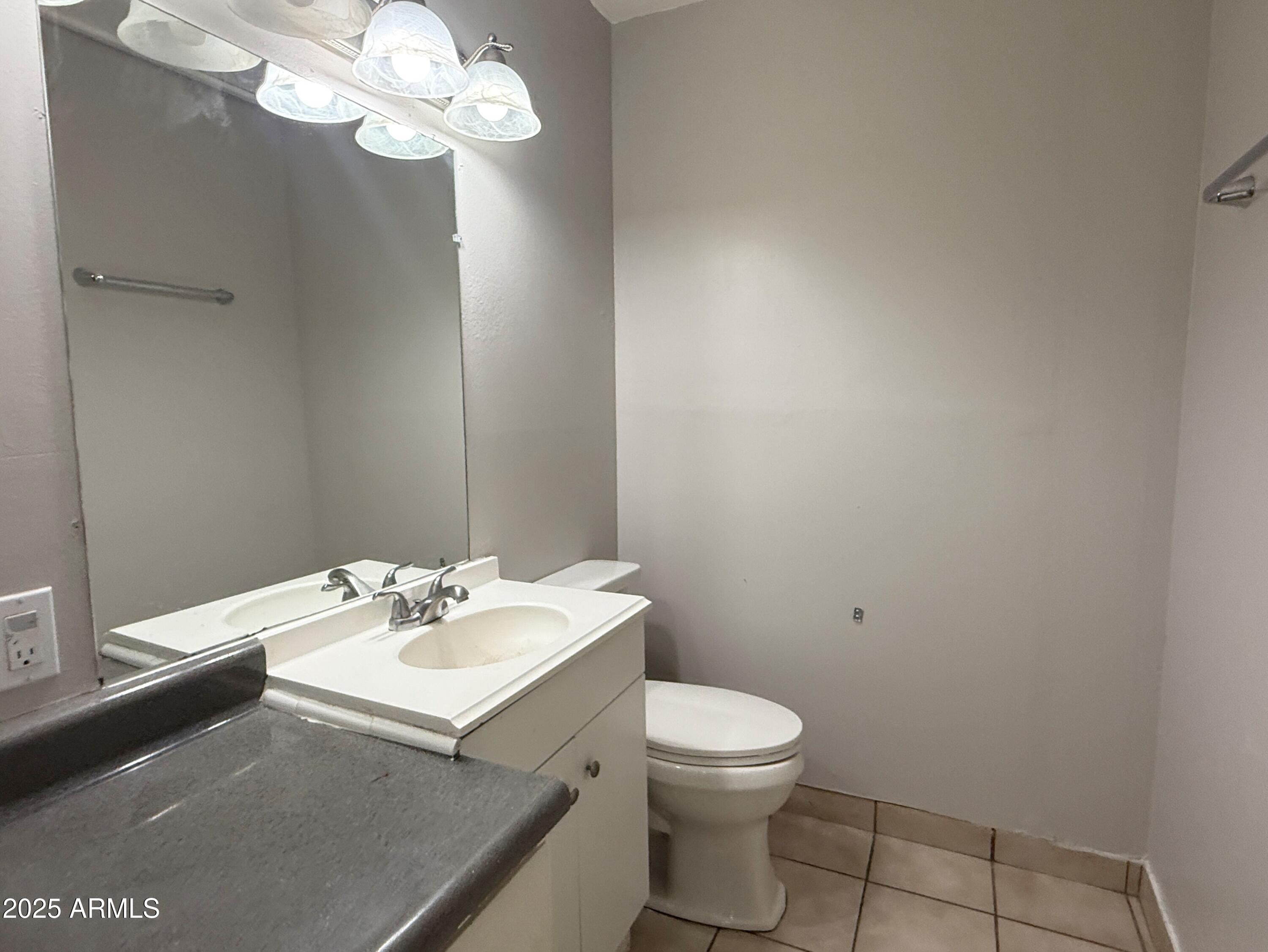 4719 North 15th Avenue, Unit 3 Phoenix, AZ 85015 - Photo 9 of 12 a bathroom with a sink a toilet and a mirror