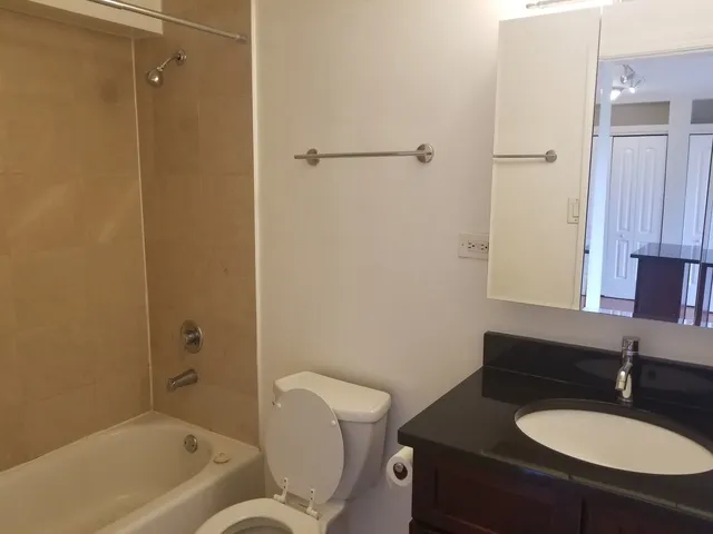 a bathroom with a granite countertop sink toilet and shower
