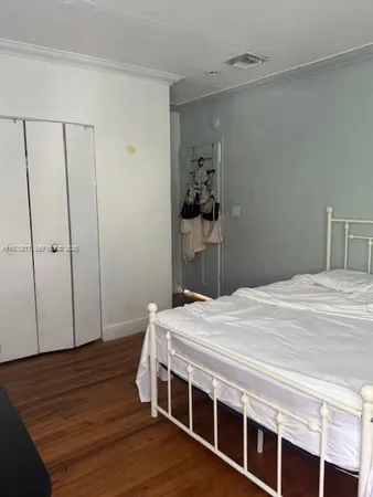a bedroom with a bed and wooden floor