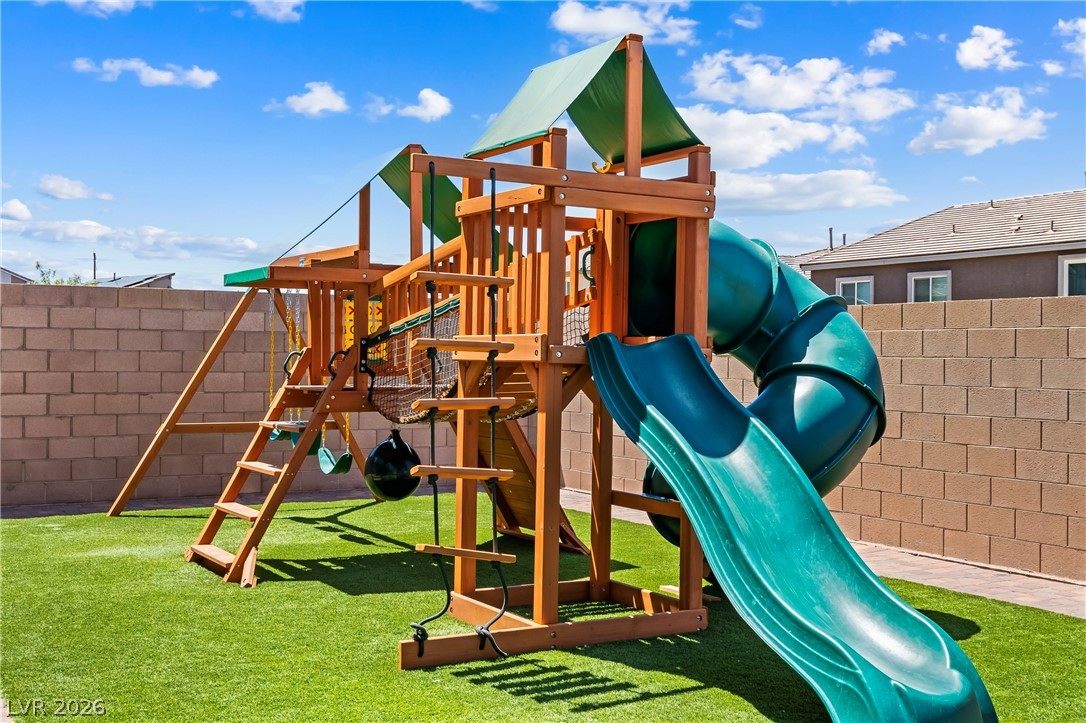 320 Isla Enclave Way Henderson, NV 89011 - Photo 38 of 49 This private yard features artificial turf and an engaging wooden playground structure, complete with slides and swings.