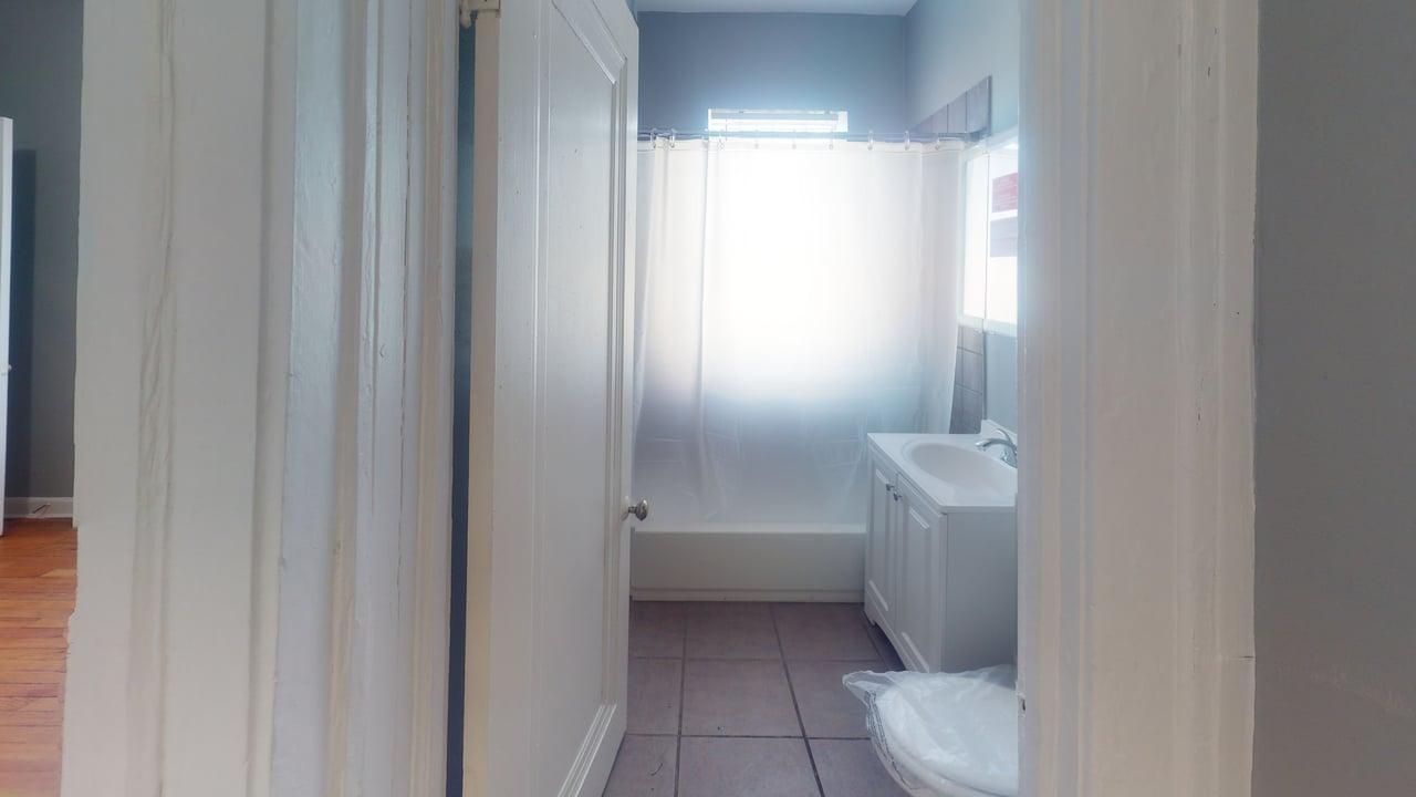 817 West 83rd Street, Unit 2N Chicago, IL 60620 - Photo 7 of 7 a bathroom with a granite countertop sink toilet and shower
