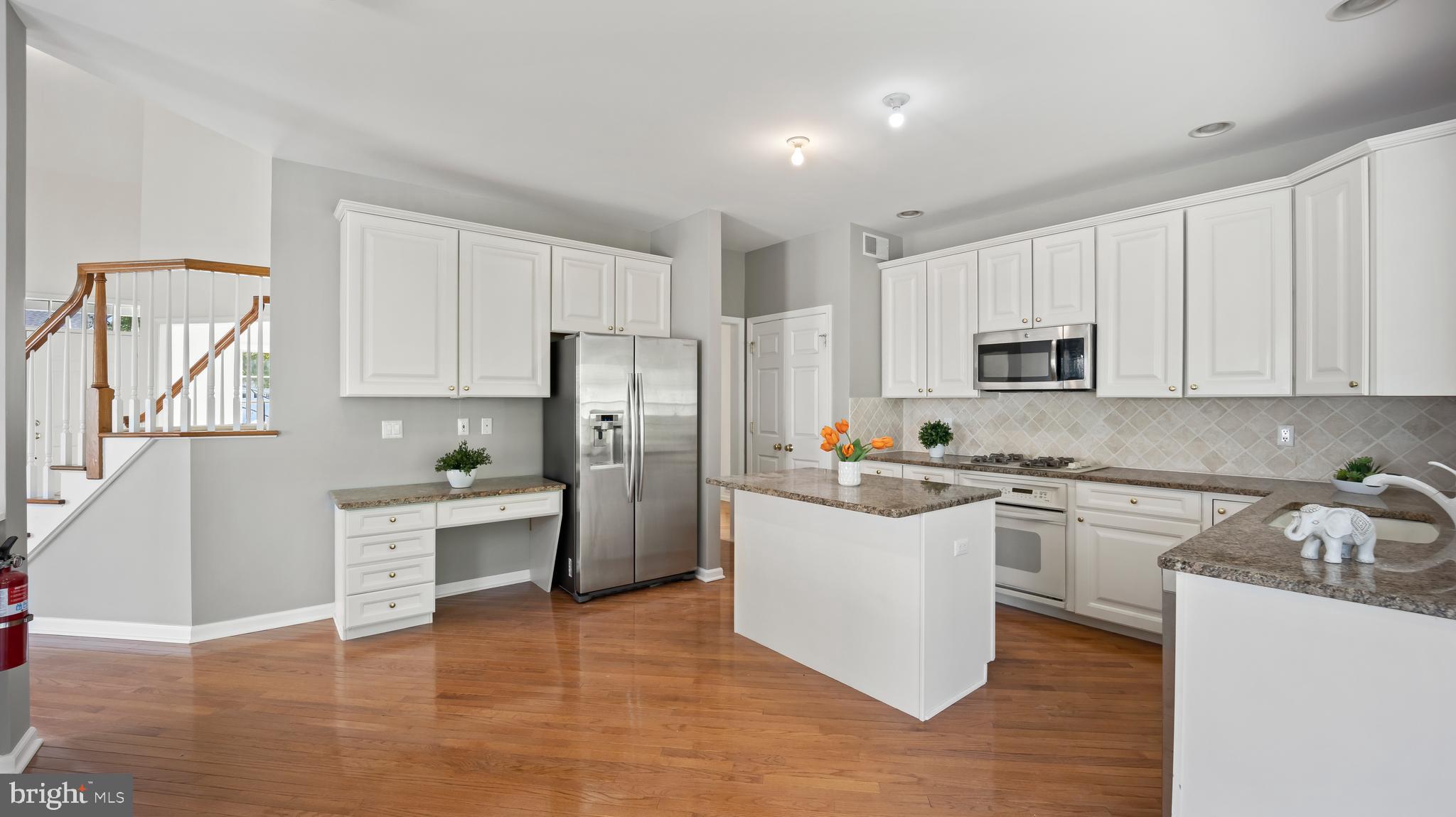8 Bethpage Drive Skillman, NJ 08558 - Photo 6 of 36 a kitchen with white cabinets and stainless steel appliances