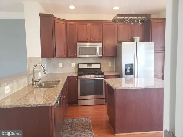 a kitchen with a refrigerator sink and cabinets