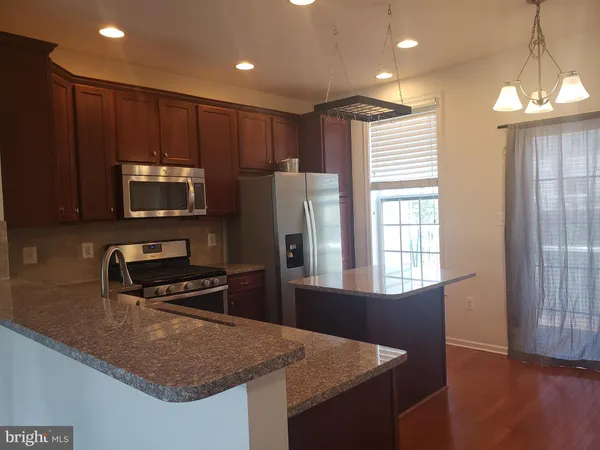 a kitchen with a refrigerator a microwave a sink and a stove