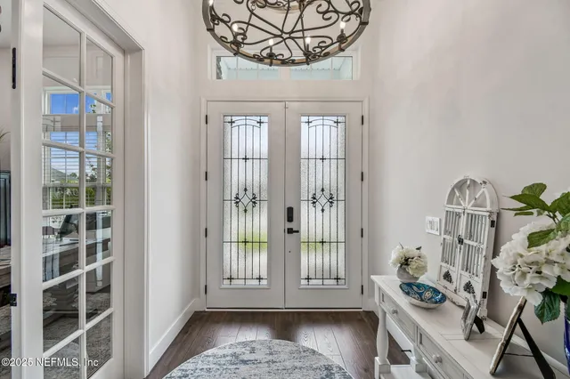 a view of a dining room with furniture a chandelier and wooden floor
