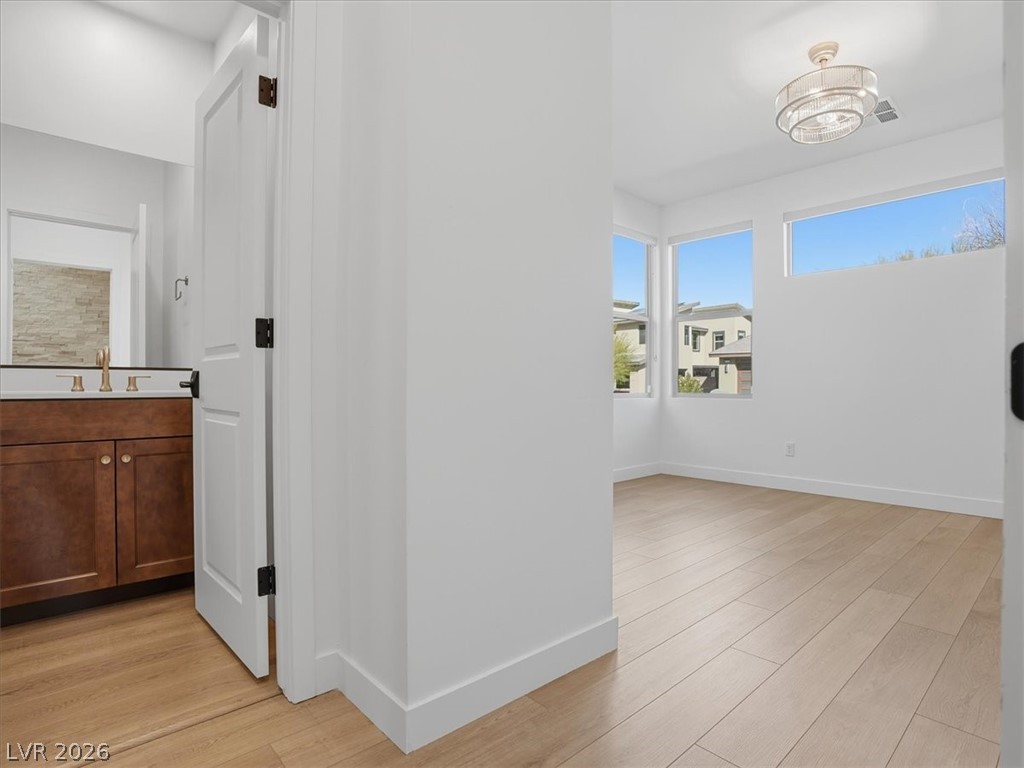9725 Starlight Ridge Avenue Las Vegas, NV 89148 - Photo 25 of 47 Bright, airy room with expansive windows and wood flooring, offering abundant natural light.