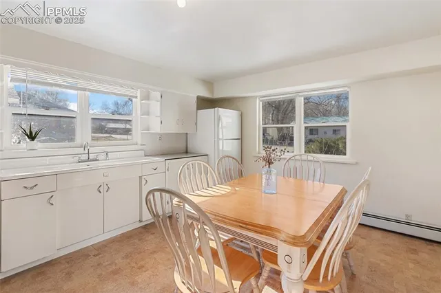 a kitchen with granite countertop a stove a sink a dining table and chairs