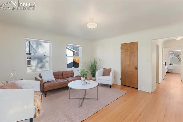 a living room with furniture and a wooden floor